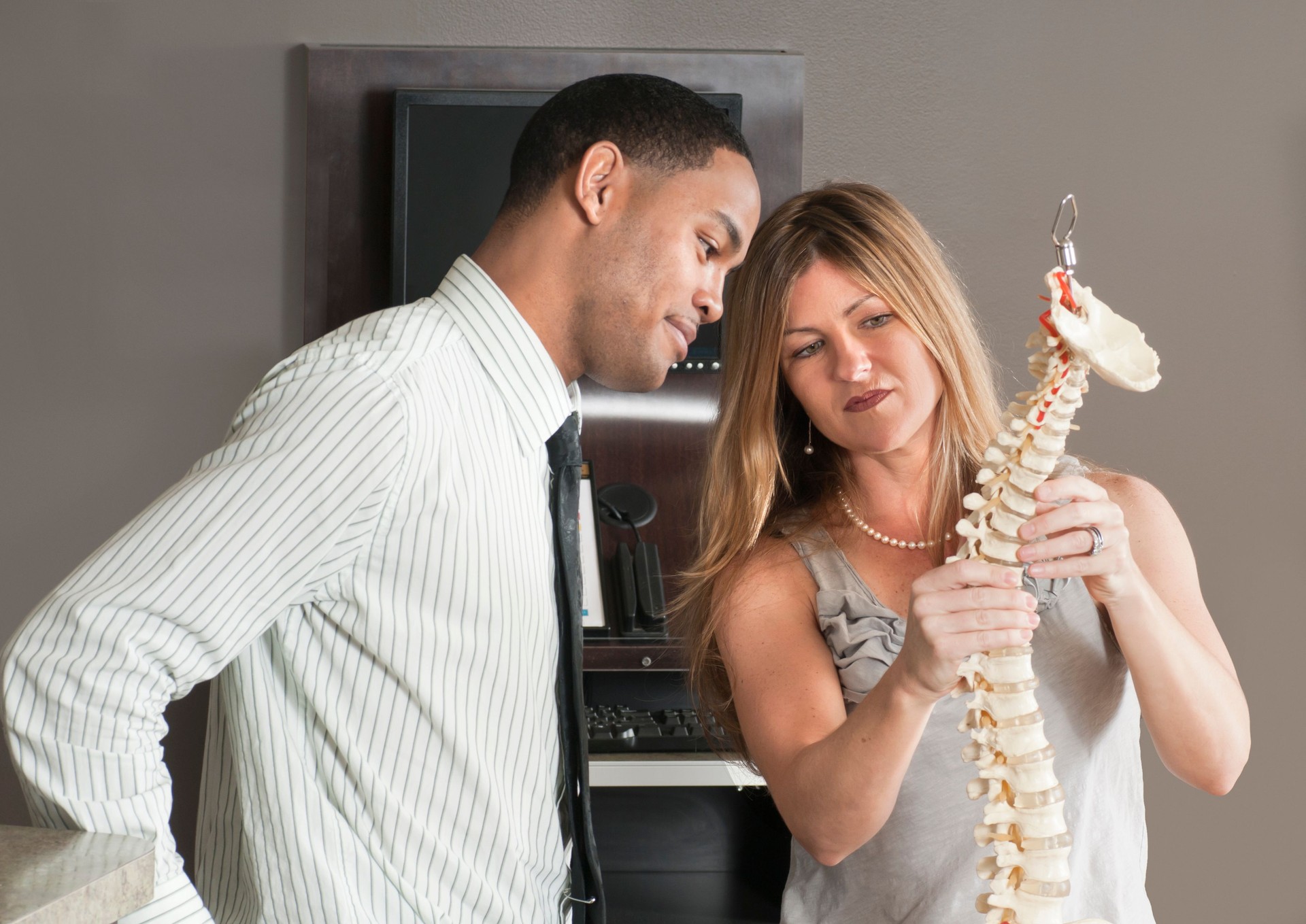 Chiropractor Showing Spine Model to Patient