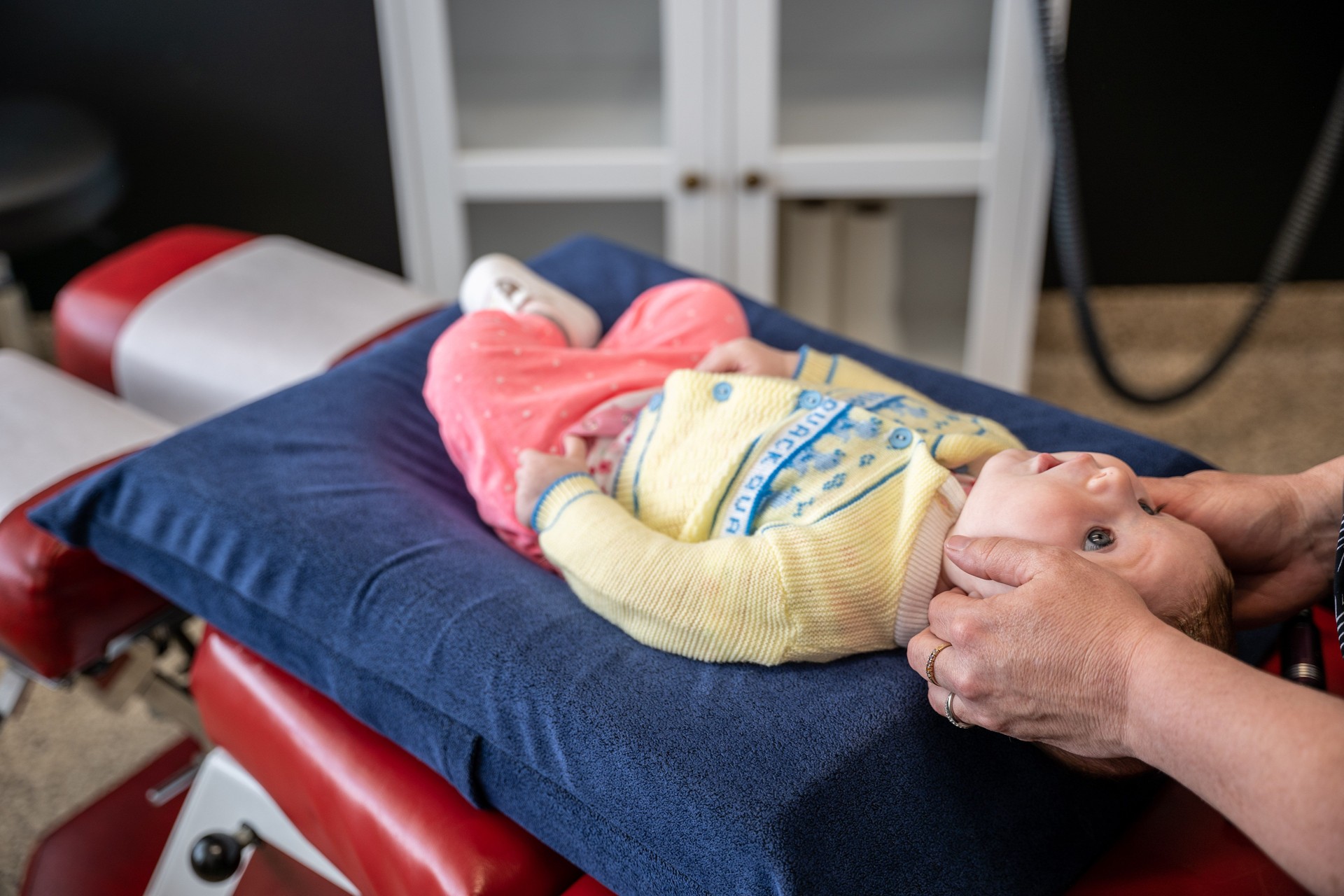 Baby getting a chiropractic examination.